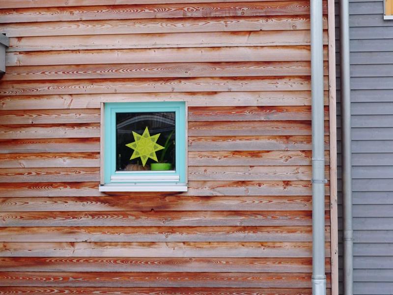 Brushing a fresh coat onto wooden clapboard siding