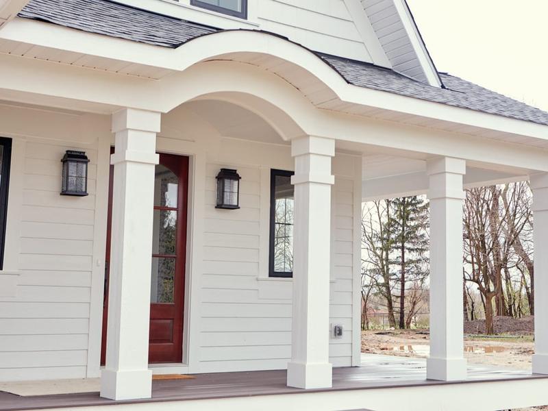 New England home with freshly painted siding, white trim and a clean porch