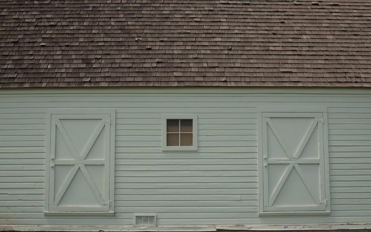 White clapboard farmhouse with painted trim in a rural New England setting